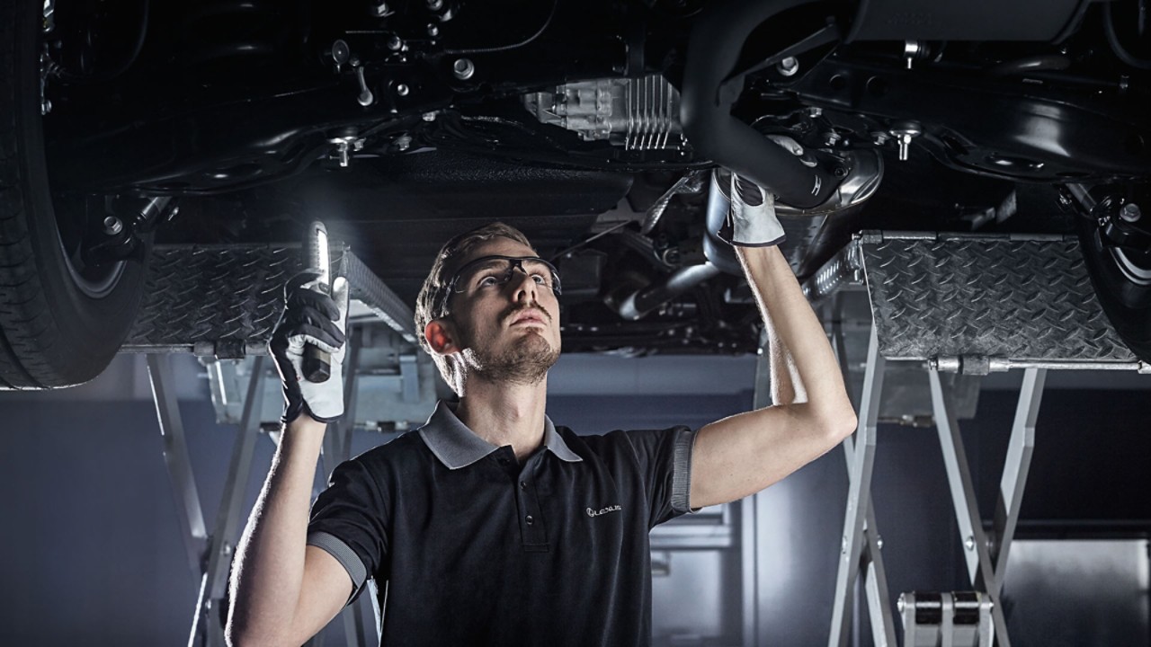 Lexus technician inspecting an cars undercarriage